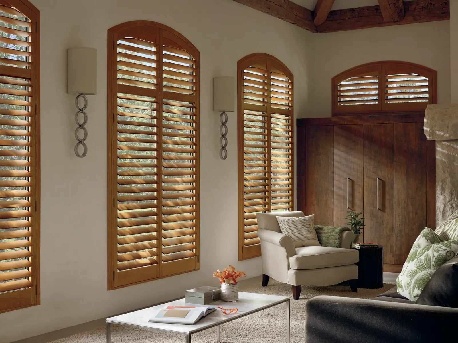 Arch-top plantation shutters custom fitted to a living room window