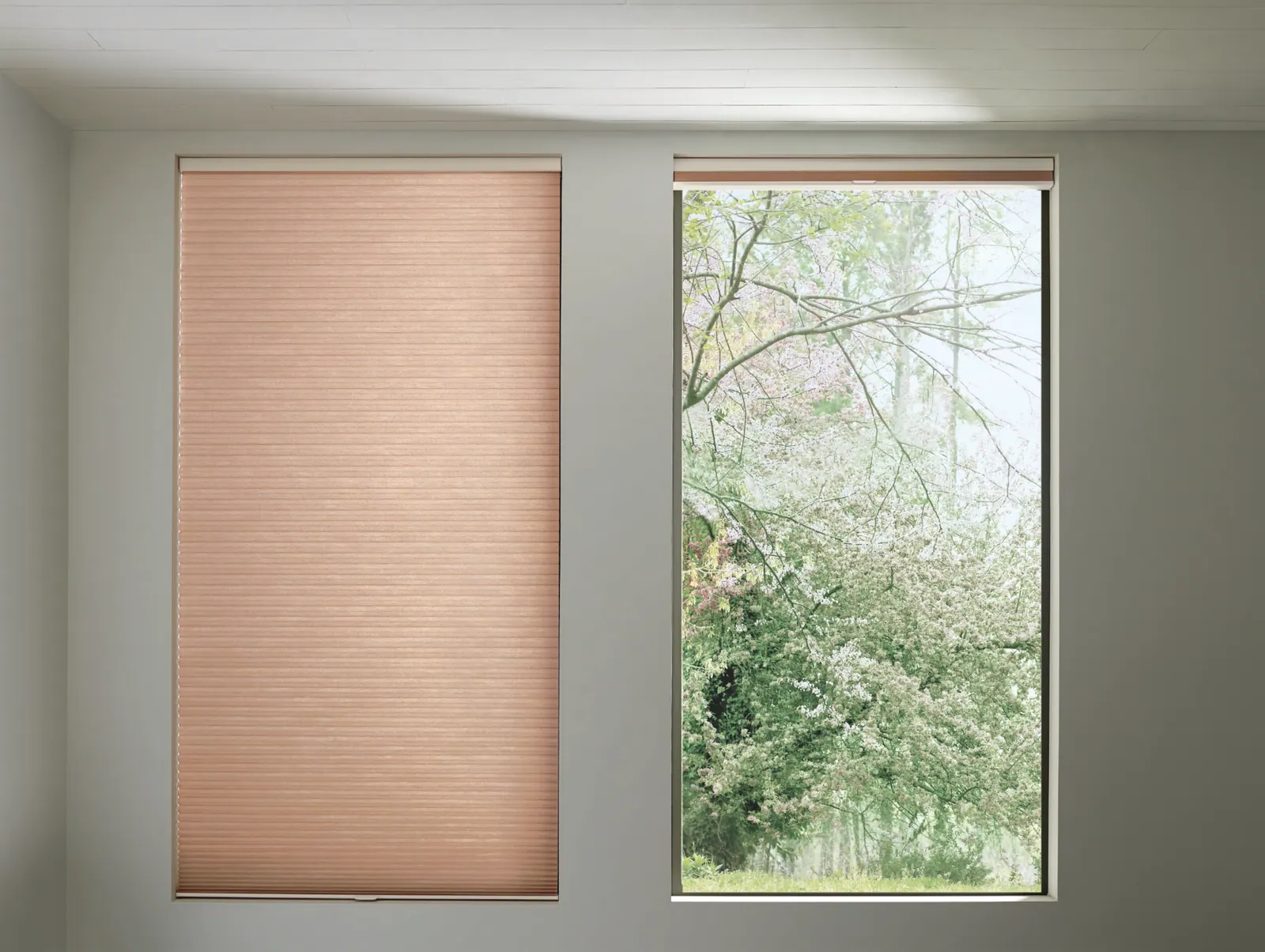 Honeycomb shades raised to a small stack above a living room window